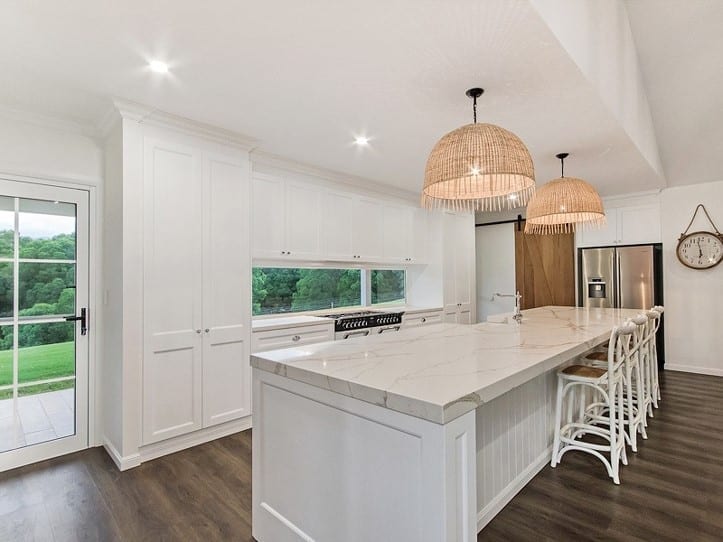 Hampton style kitchen with shaker cabinetry and dark wood floors