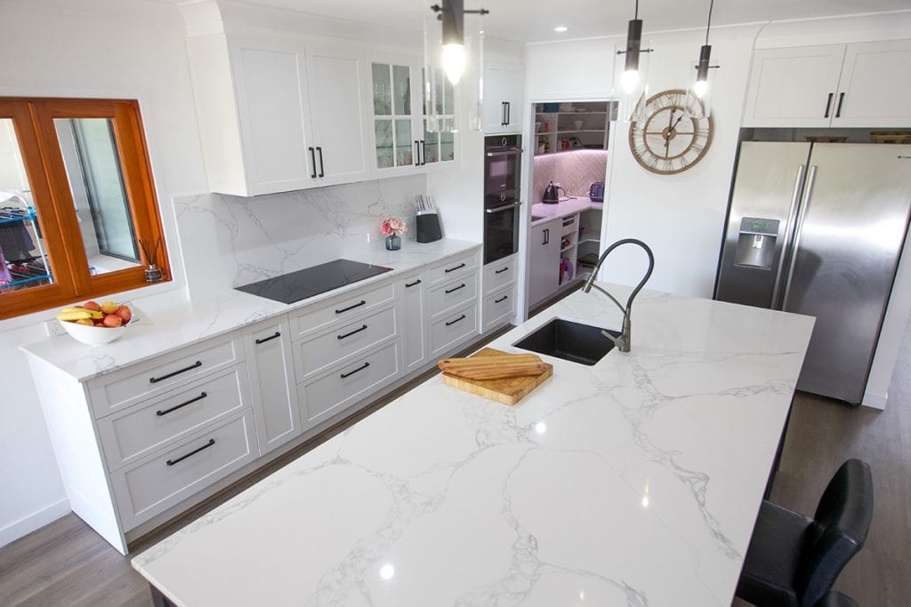 Top down view of white marble benches with wooden chopping board on bench