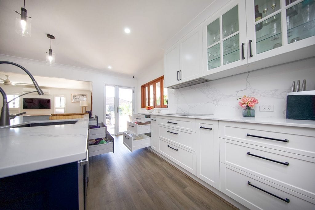 White kitchen drawers and cupboards alongside kitchen wall