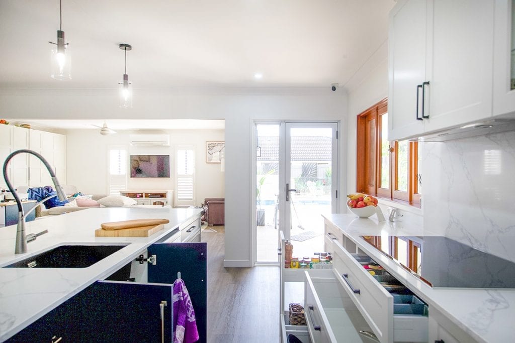 Open drawers and cupboards beneath stove and sink