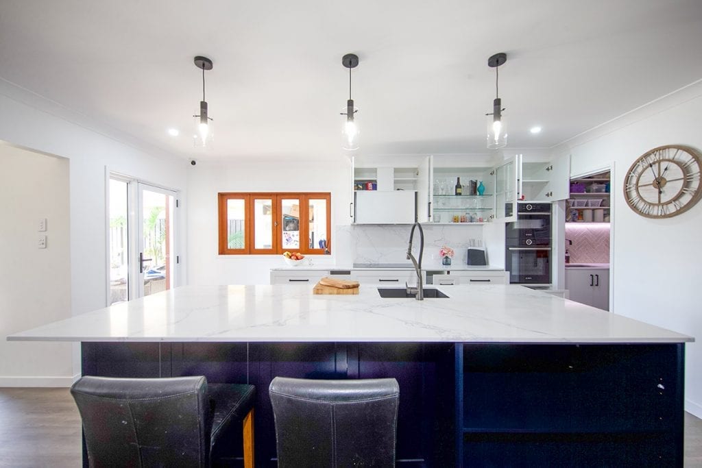 View of island bench to wide four pane natural timber window