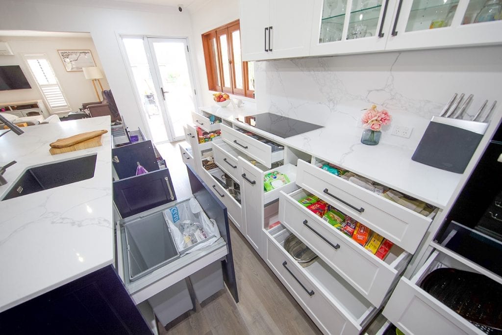 Open kitchen storage drawers and cupboards and open bin drawer