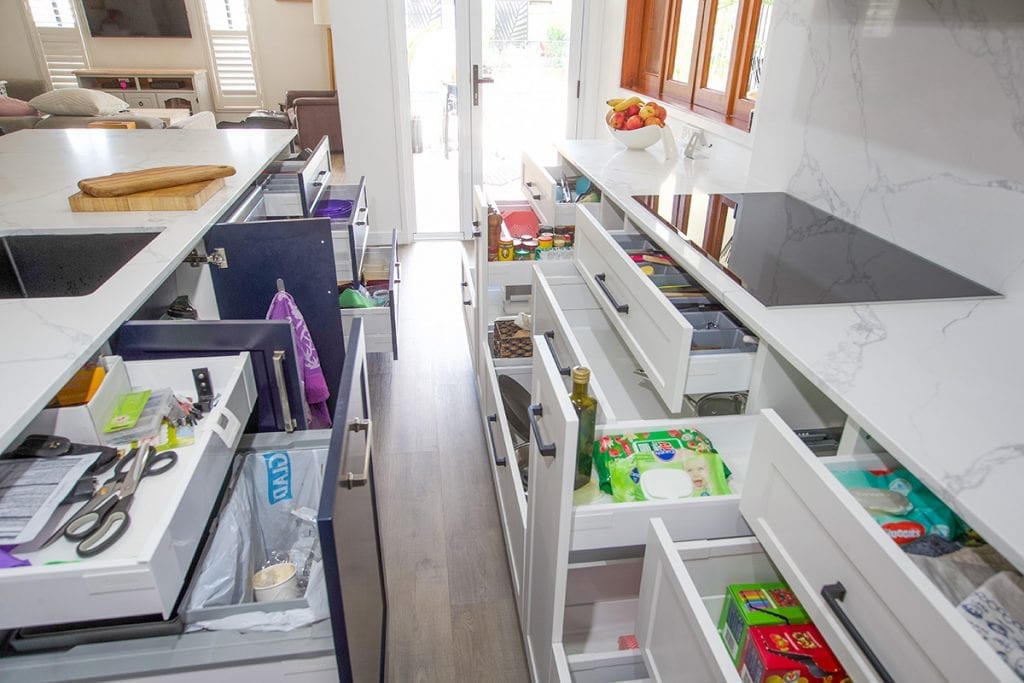 Top down view of white kitchen drawers beneath stove hotplate