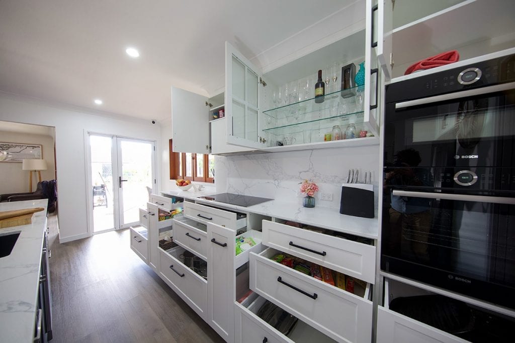 Kitchen storage drawers beside black double door bosch stove