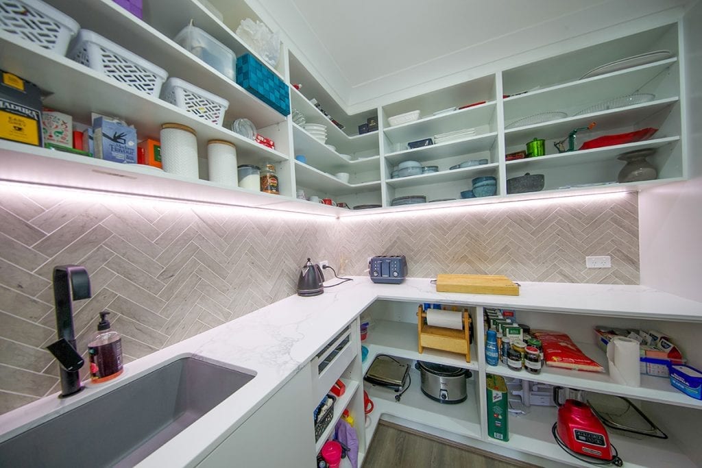 Wide narrow overhead storage cupboards inside walk in pantry