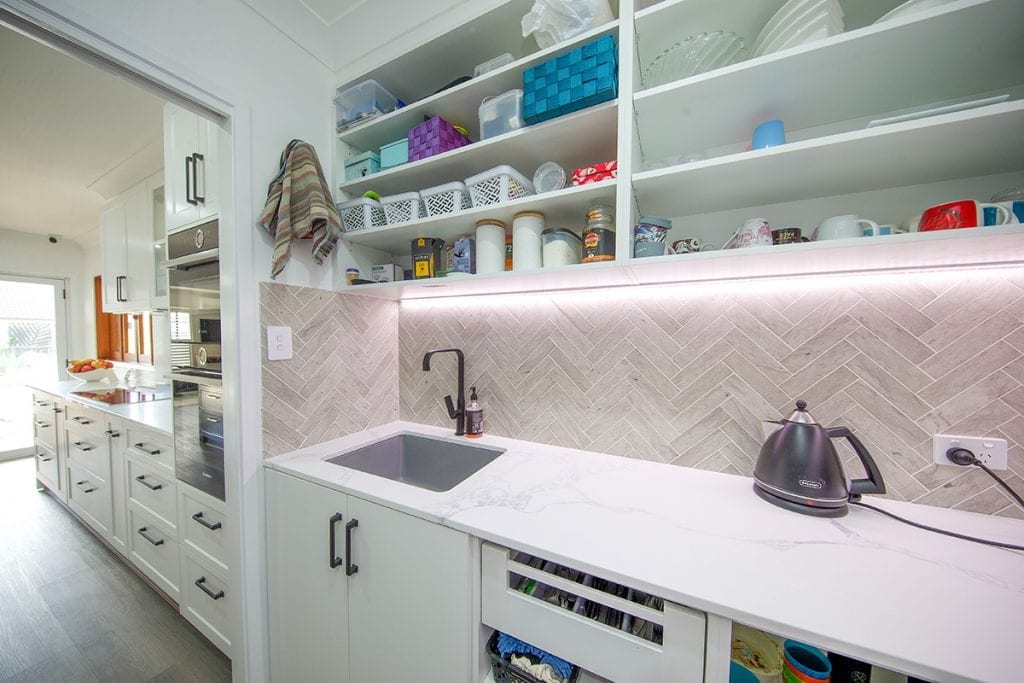Inside kitchen storage area with marble bench and single sink
