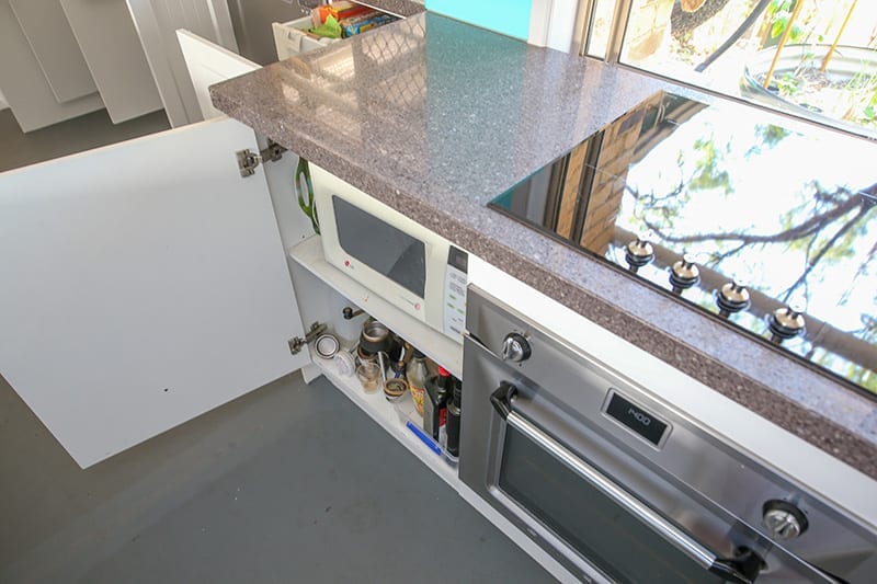 Top down view of microwave cupboard and four plate stove top