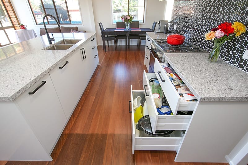 Open sliding kitchen drawers for storage of cutlery and pots