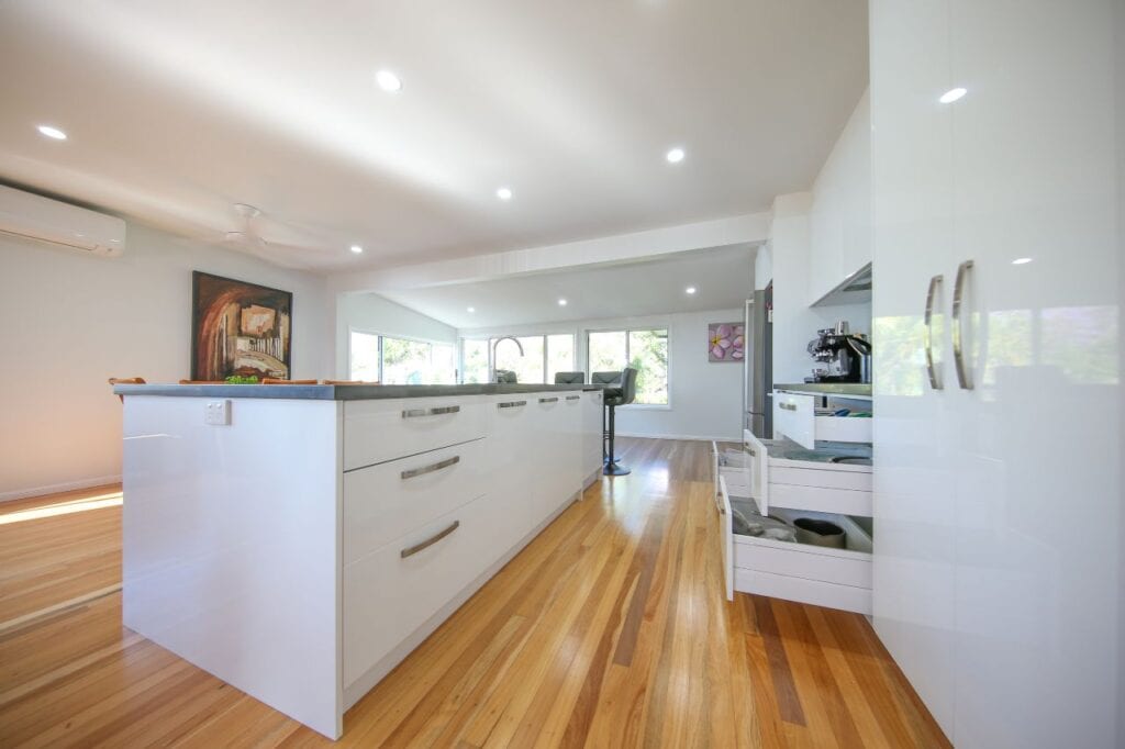 Closed double white pantry doors and polished wooden kitchen corridor floor