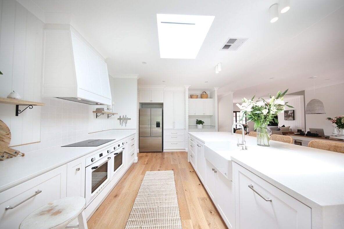 natural light with wooden floors in white renovated kitchen
