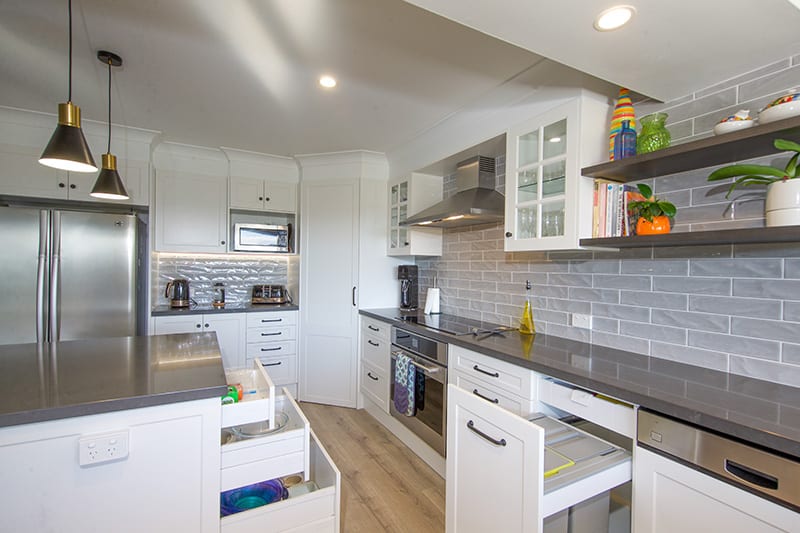 large kitchen with wooden floors and white cabinets