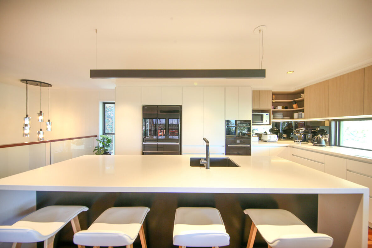 modern renovated kitchen with grey overhead statement lighting and chandelier