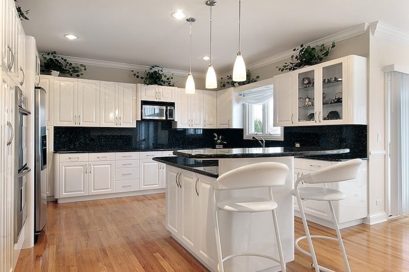 Dark coloured backsplash in white Hampton style kitchen