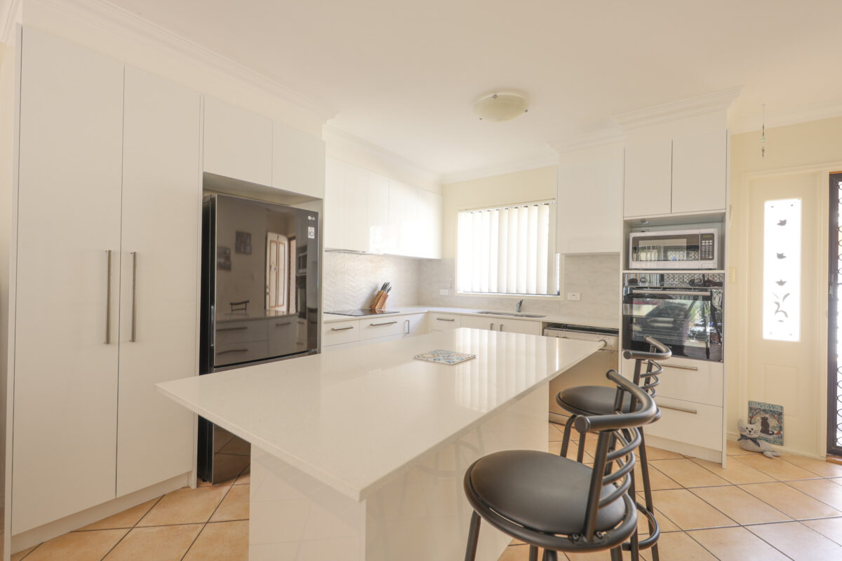 kitchen renovation with glossy white island bench and white cabinetry