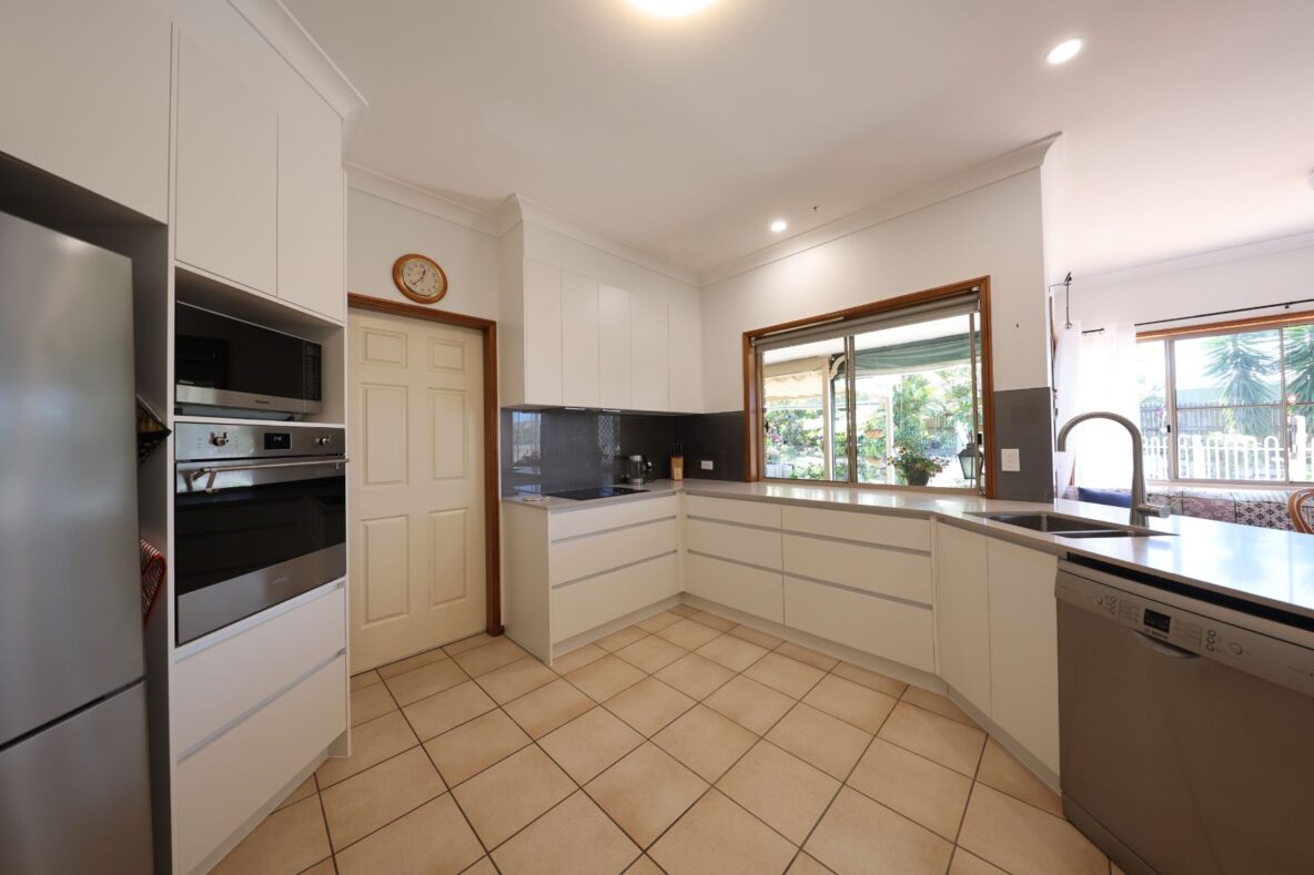 modern kitchen renovation with white cabinetry and stainless steel appliances