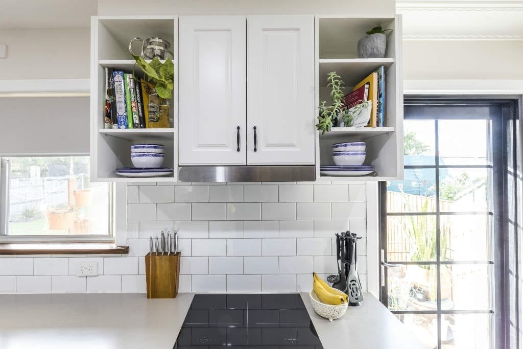 White tile backsplash behind electric stove