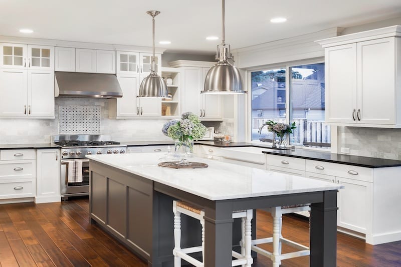 modern country kitchen with dark Wooden floors and stainless steel accents and black benchtops