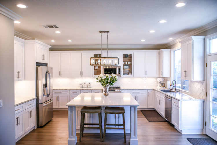 Modern shaker style kitchen white cabinetry with gold handles and square island bench